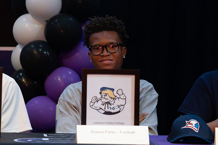 A teen boy smiles with his Lebanon Valley College letter of intent
