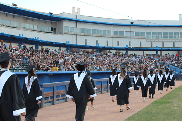 Graduates walk onto the field before the ceremony