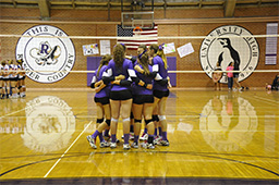 Girls Volleyball players huddled on the court